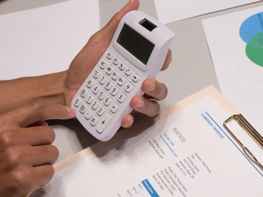 Calculatrice tenue au-dessus d'une facture d'entreprise