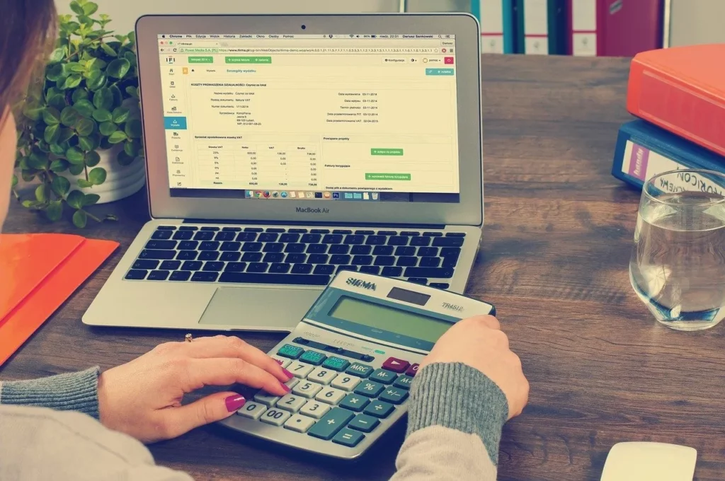Comptable saisissant des factures sur ordinateur et calculatrice