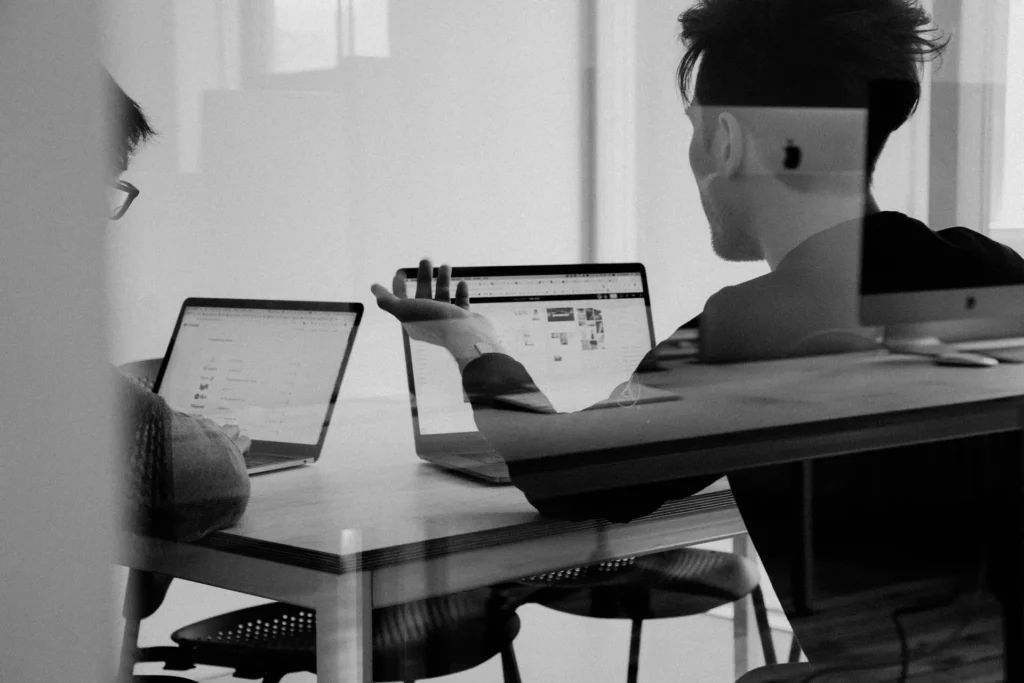 Deux consultants Microlog échangent autour d'un projet Divalto devant leurs ordinateurs